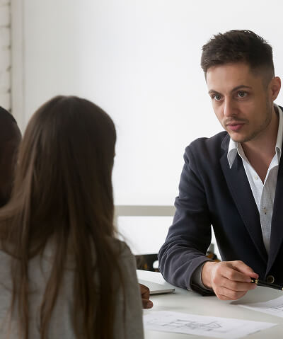 architect realtor designer consulting interracial couple with house plan